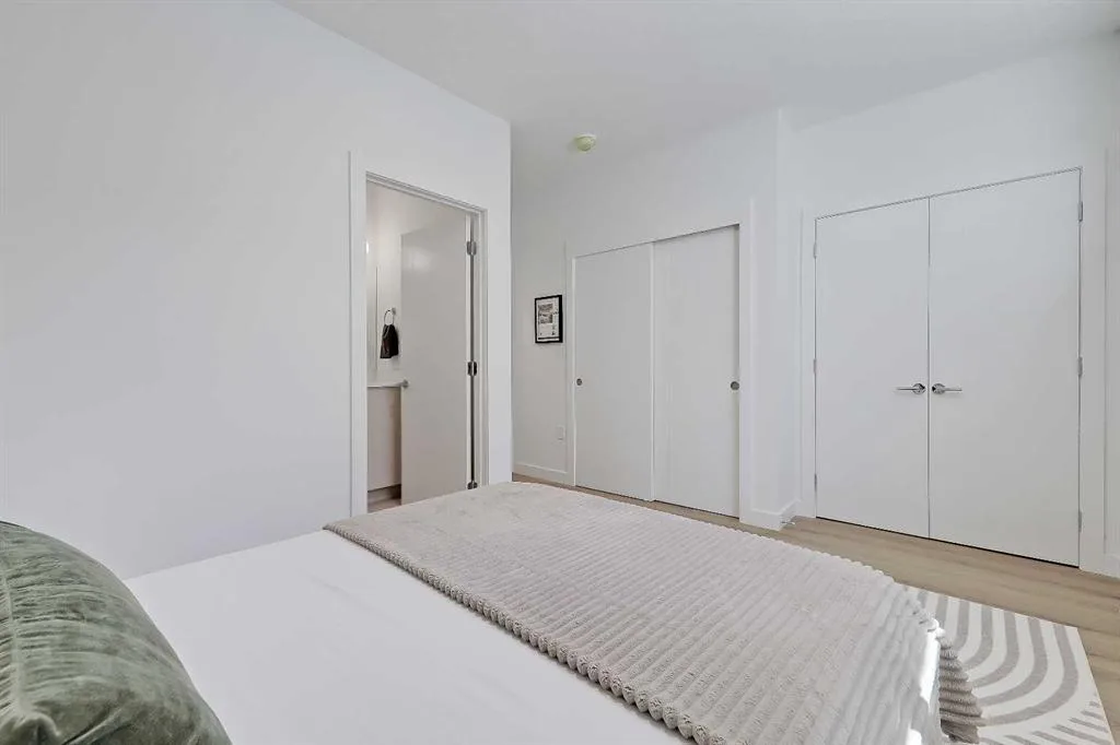 Primary bedroom foreground showing closet doors and ensuite entry