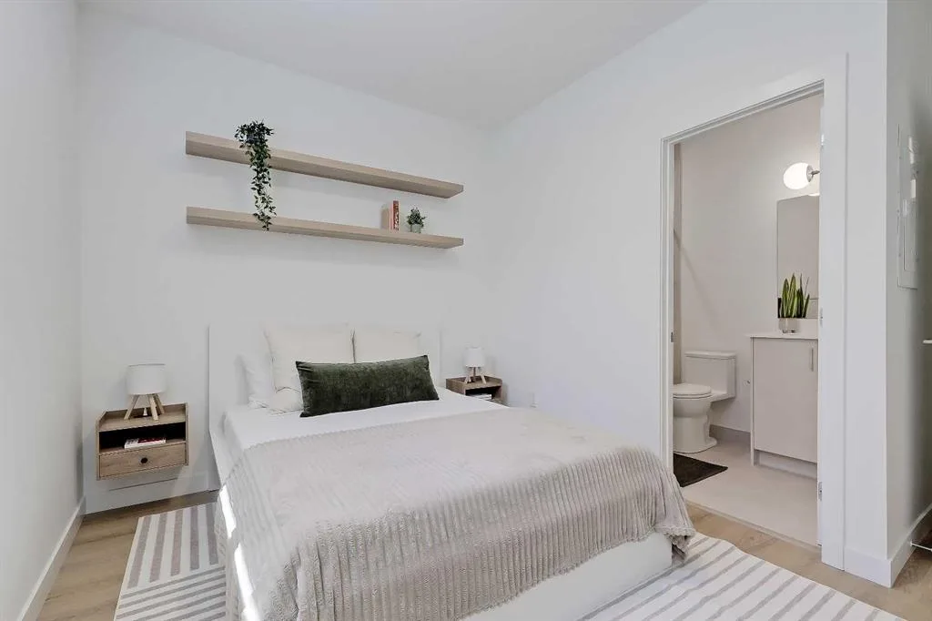 Primary bedroom with view into the attached ensuite bathroom