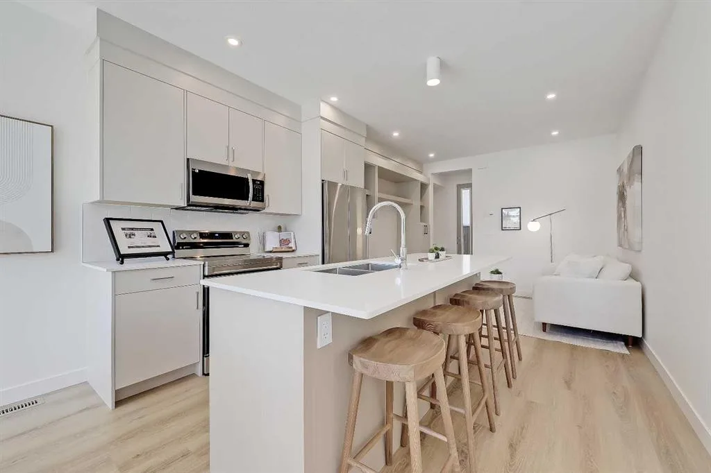 Kitchen island view opening into the living room with a cream sofa