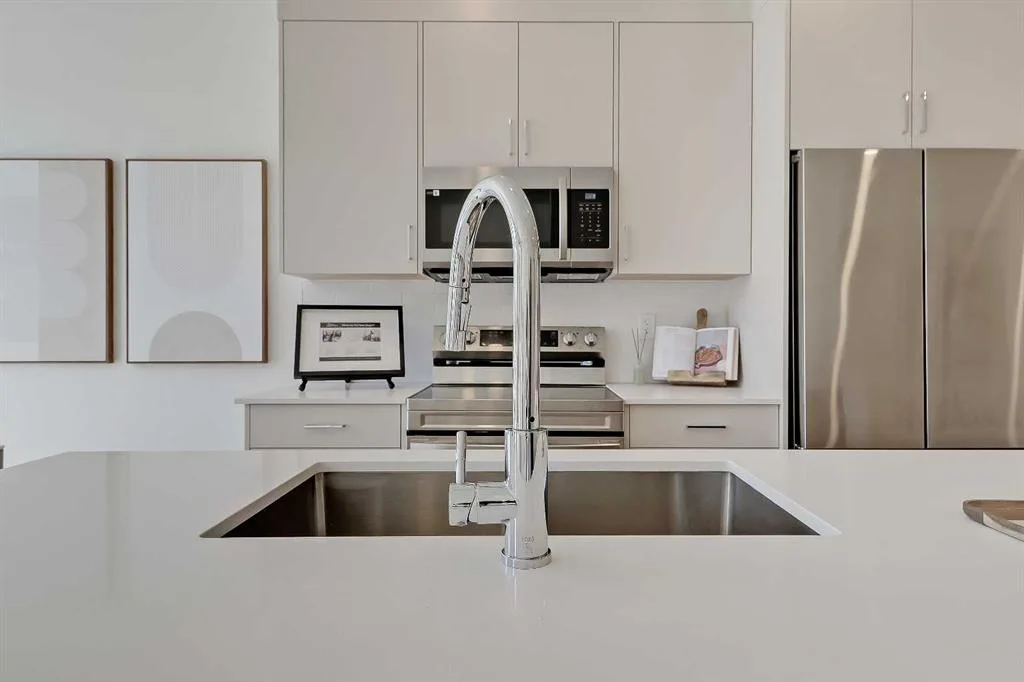 Kitchen island sink and pull-down faucet with range and fridge behind