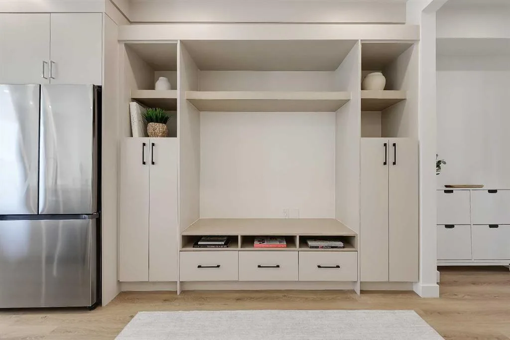 Close-up of built-in media wall cabinetry beside the refrigerator