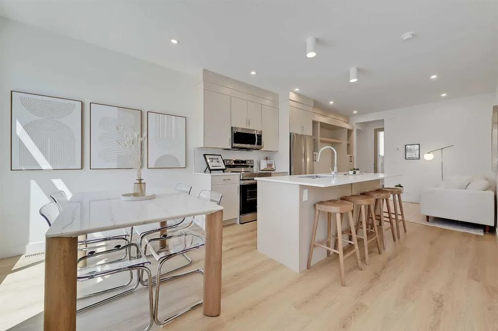 Open-concept main floor showing dining table, kitchen island, and living room in a Glenbrook Urban Multi-level Home